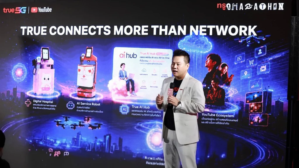 ผู้บริหารทรูบรรยายบนเวทีหน้าจอพรีเซนเทชันกราฟิก True AI Hub, Digital Hospital, AI Service Robot และ YouTube Ecosystem